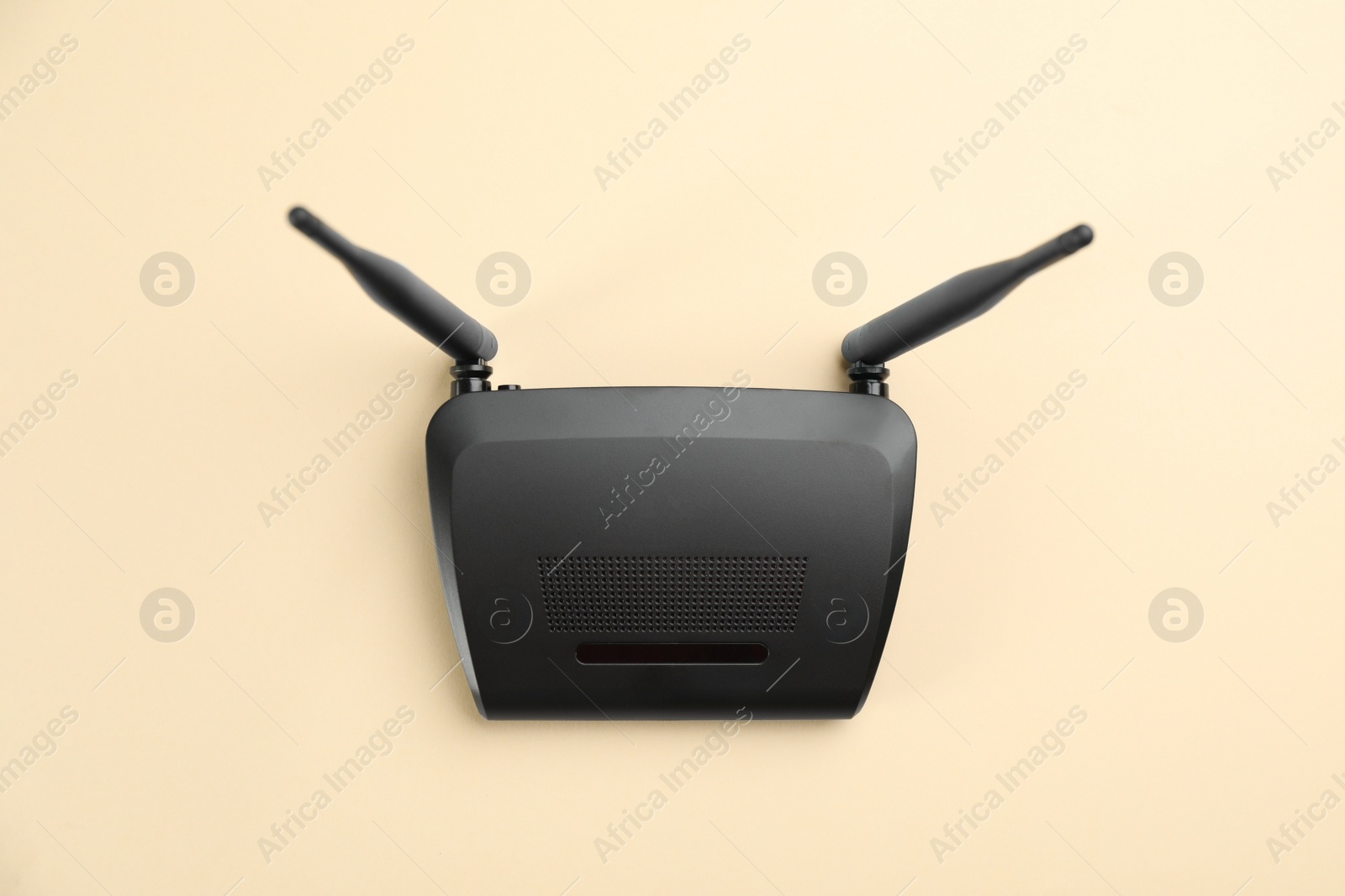 Photo of Modern Wi-Fi router on beige background, top view