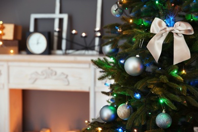 Photo of Christmas tree with beautiful decorations indoors, closeup. Stylish interior element