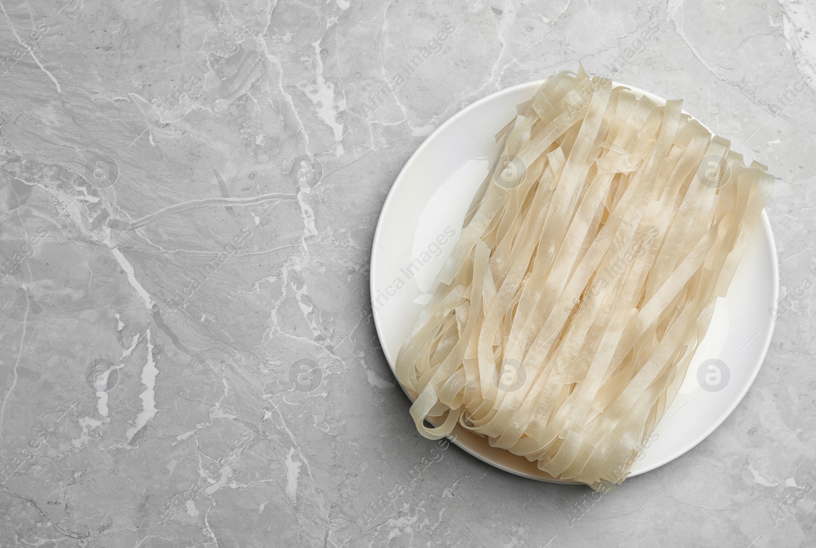 Photo of Block of rice noodles on light grey marble table, top view. Space for text