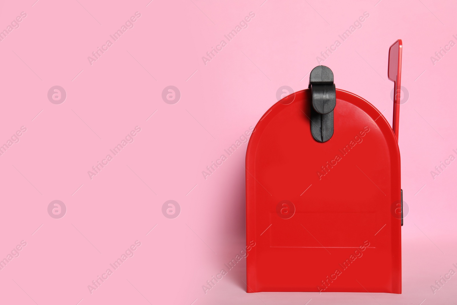 Photo of Closed red letter box on pink background. space for text