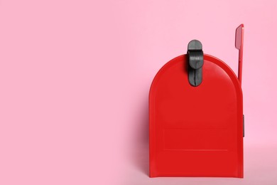 Photo of Closed red letter box on pink background. space for text