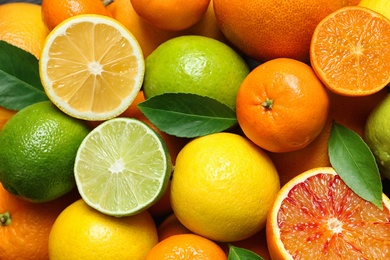 Photo of Many different citrus fruits as background, top view