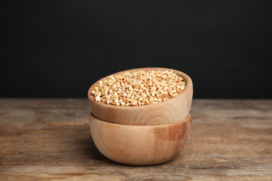 Green buckwheat on wooden table against dark background