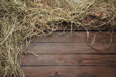 Photo of Frame made of dried hay on wooden table, top view. Space for text