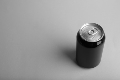 Photo of Black can of energy drink on light grey background. Space for text