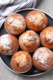 Delicious sweet muffins on light grey textured table, top view