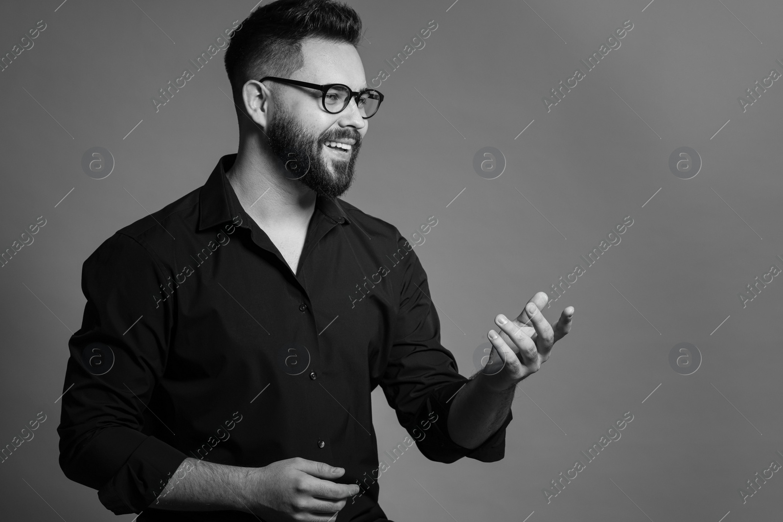 Photo of Portrait of handsome bearded man on grey background, space for text. Black and white effect