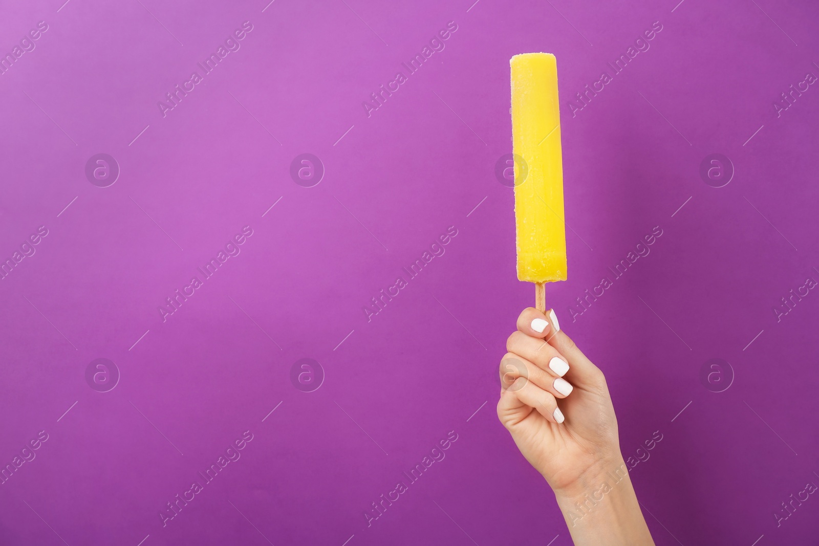 Photo of Woman holding yummy ice cream on color background. Focus on hand