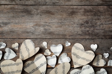 Photo of Paper hearts with music notes and space for text on wooden background, flat lay