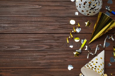 Photo of Colorful party hats and other festive items on wooden table, flat lay. Space for text