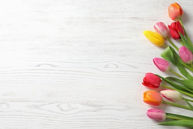 Photo of Beautiful tulips and space for text on wooden background, top view. Spring flowers