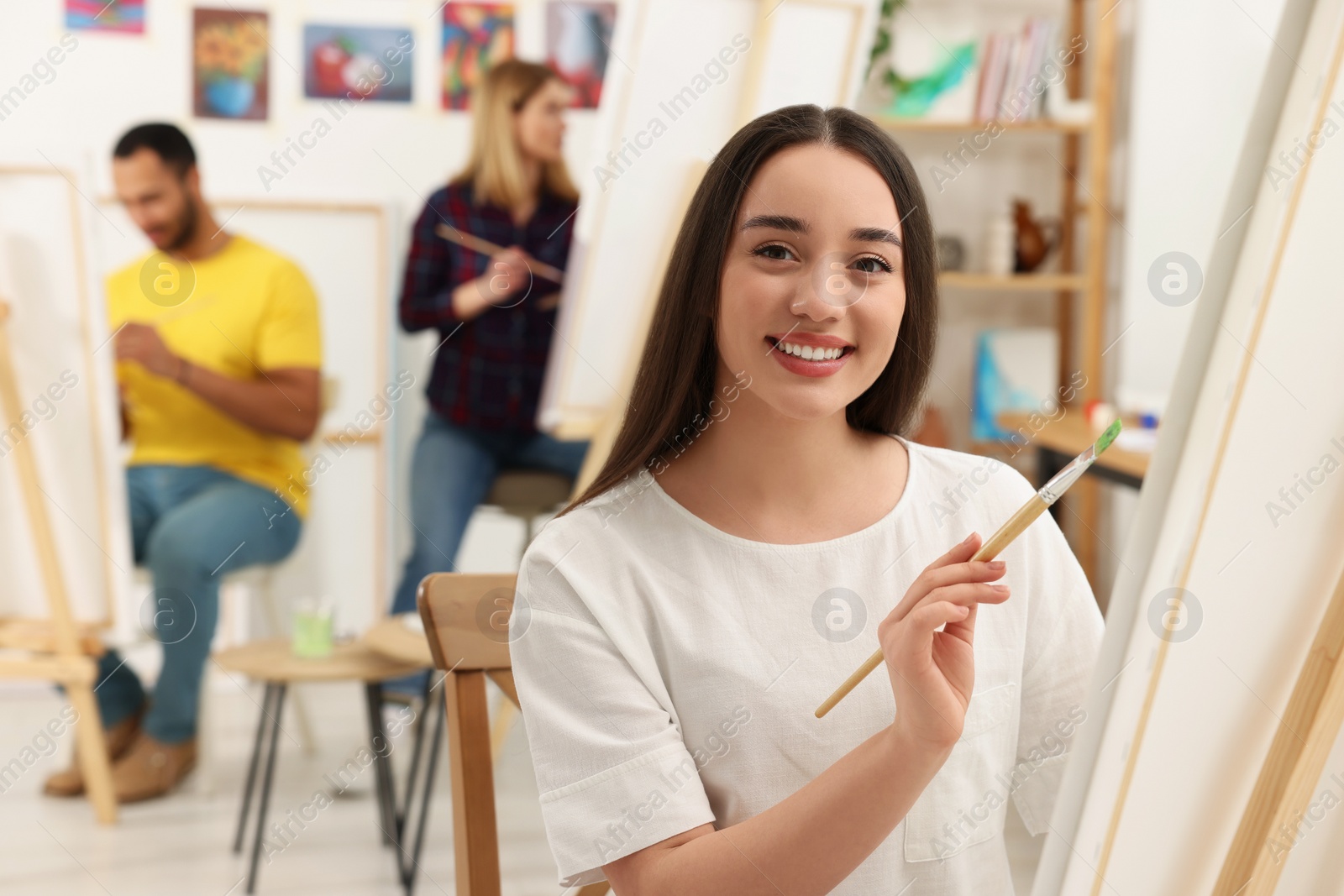 Photo of Group of students attending painting class in studio. Creative hobby