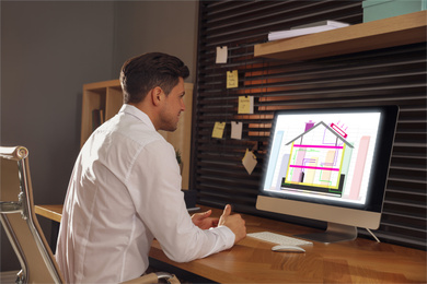 Engineer at work. Man projecting house in office