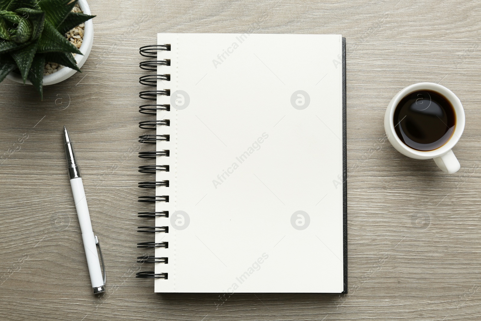 Photo of Flat lay composition with open notebook on light wooden table. Space for text