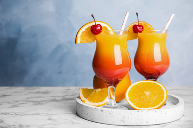 Photo of Fresh alcoholic Tequila Sunrise cocktails on marble table