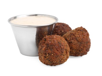 Photo of Delicious falafel balls and sauce isolated on white