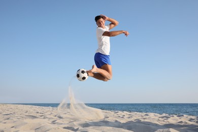 Photo of Man playing football on beach near sea