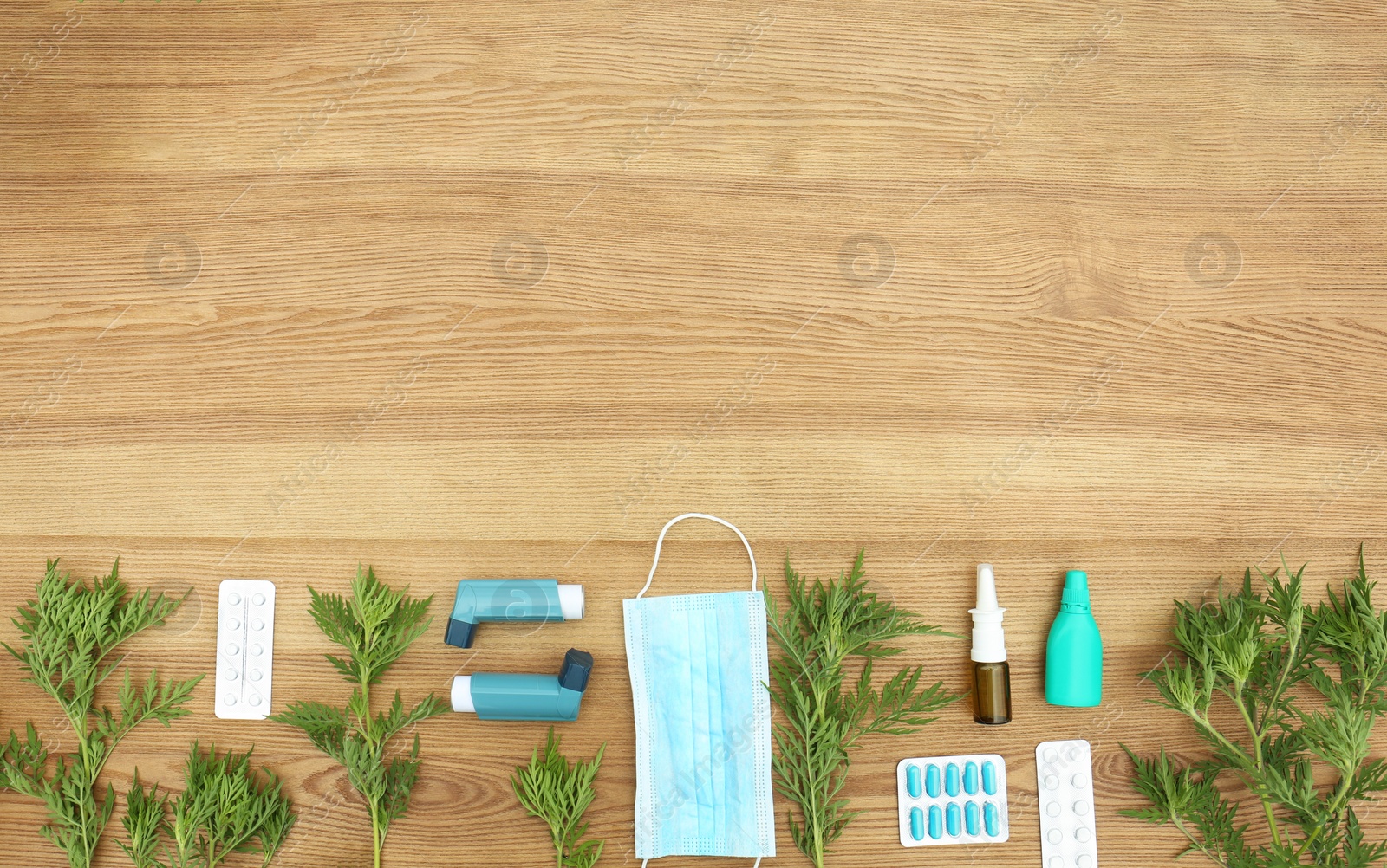 Photo of Flat lay composition with ragweed plant (Ambrosia genus) on wooden background, space for text. Seasonal allergy