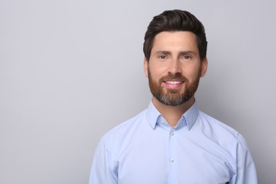 Portrait of handsome man on light grey background, space for text