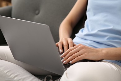 Photo of Woman working with laptop on sofa, closeup