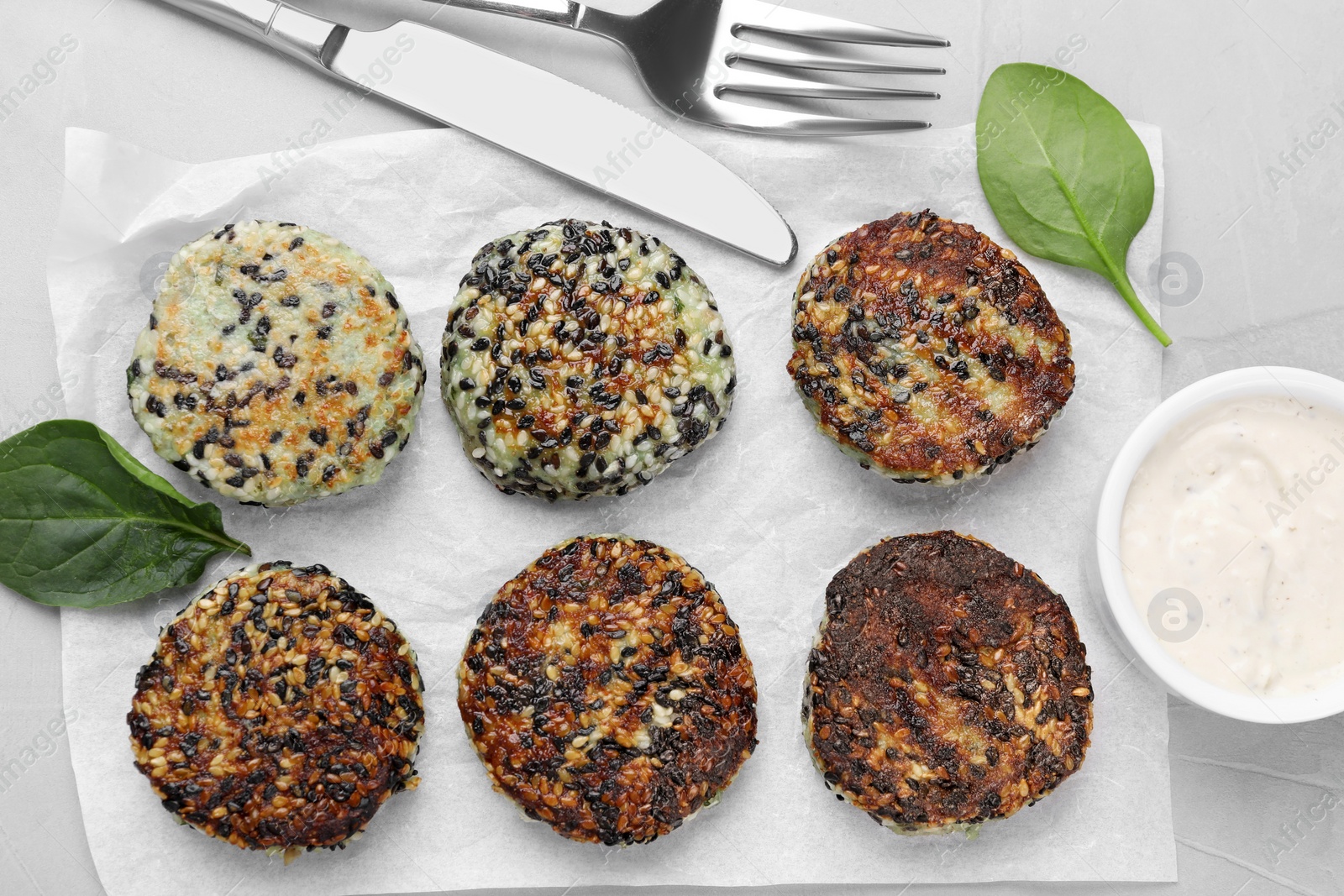 Photo of Delicious vegan cutlets with sesame served on white table, flat lay