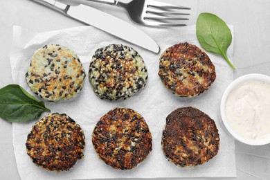 Delicious vegan cutlets with sesame served on white table, flat lay