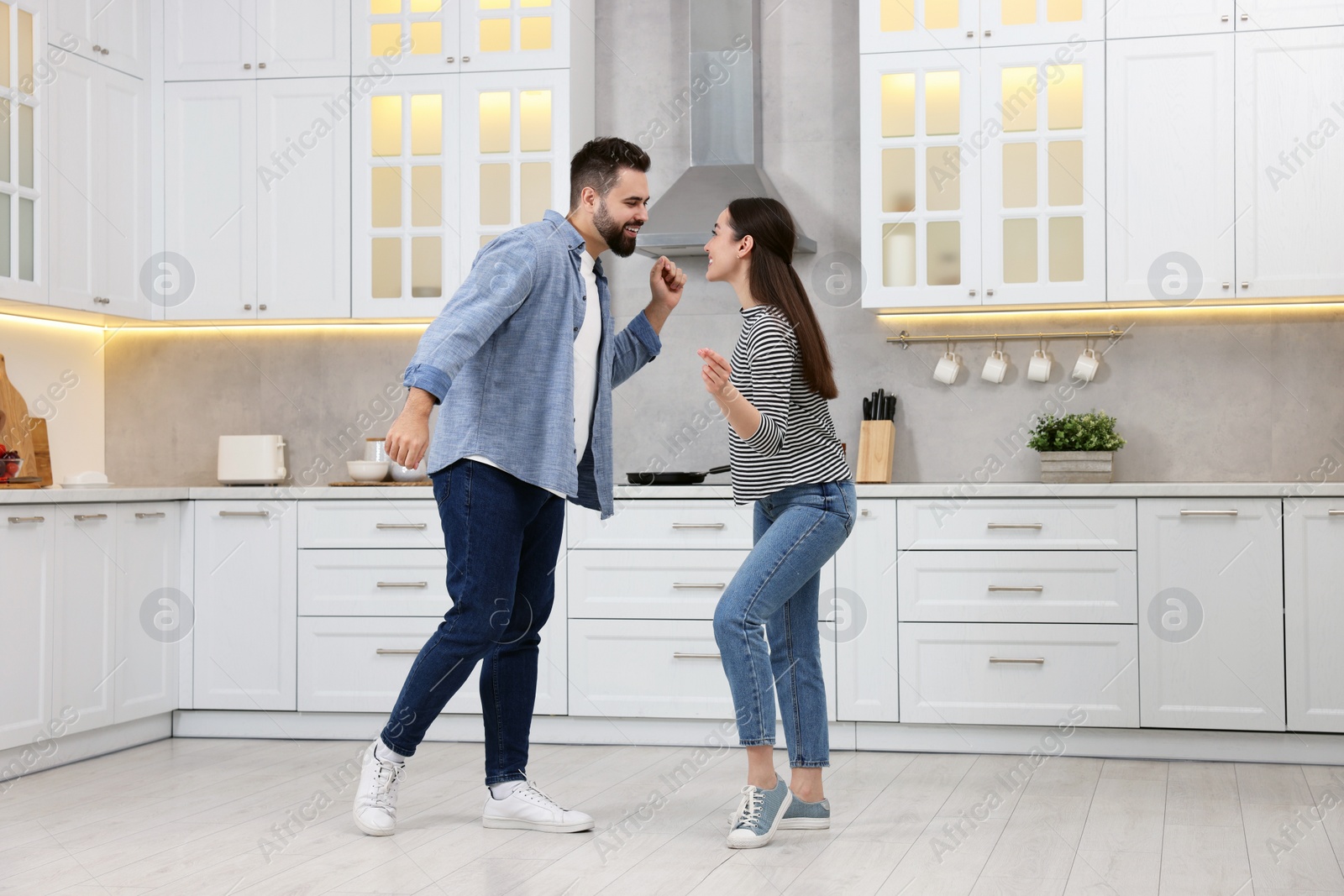 Photo of Happy lovely couple dancing together in kitchen