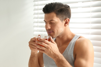 Man with cup of tea near window. Lazy morning