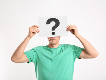 Photo of Man holding paper with question mark on white background