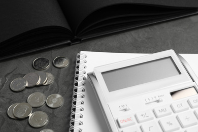 Photo of Calculator, notebook and money on dark grey table, closeup. Tax accounting