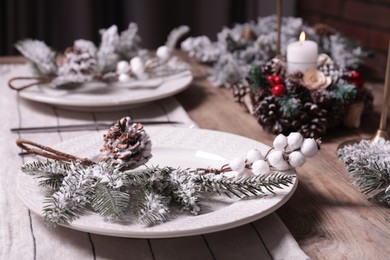 Plate with cutlery and festive decor on wooden table