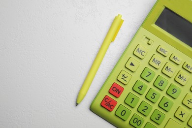 Calculator and pen on white table, top view. Space for text