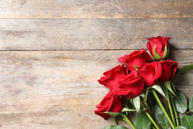 Photo of Beautiful red rose flowers on wooden background, top view