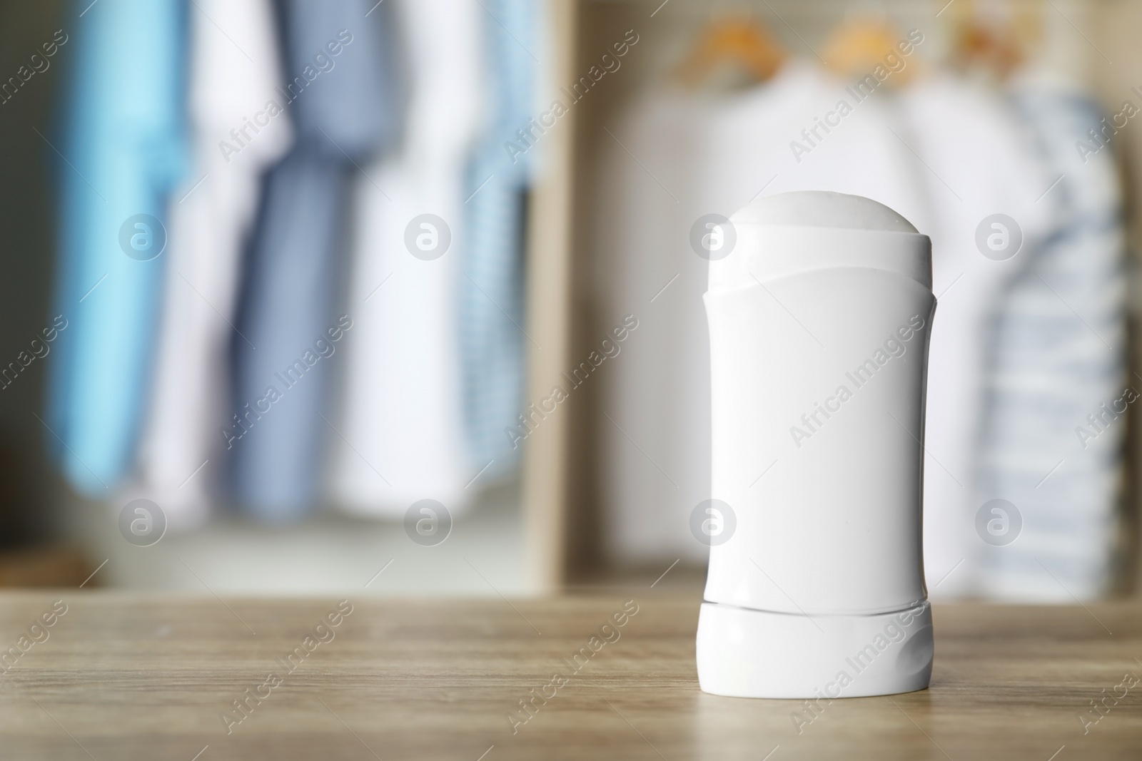 Photo of Deodorant on wooden table indoors. Space for text