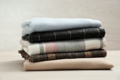 Stack of cashmere clothes on wooden table