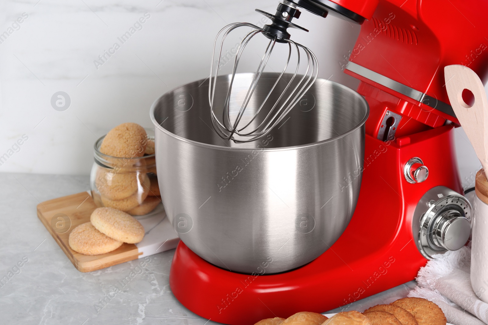 Photo of Modern red stand mixer and cookies on light gray marble table