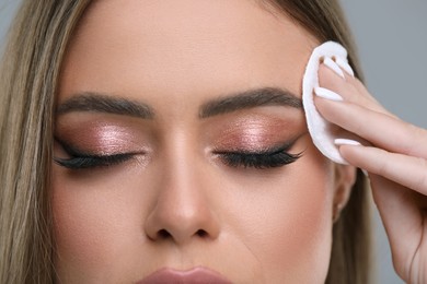 Woman removing makeup with cotton pad, closeup