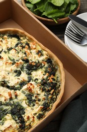 Photo of Delicious homemade spinach quiche in carton box, closeup