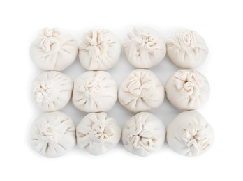 Photo of Many uncooked khinkali (dumplings) isolated on white, top view. Georgian cuisine
