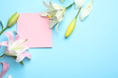 Photo of Flat lay composition with beautiful blooming lily flowers and card on color background