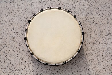 Photo of Drum on grey table, top view. Percussion musical instrument