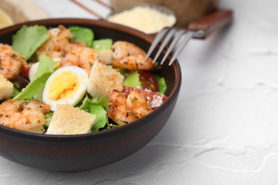 Photo of Delicious Caesar salad with shrimps and fork served on white table, closeup. Space for text