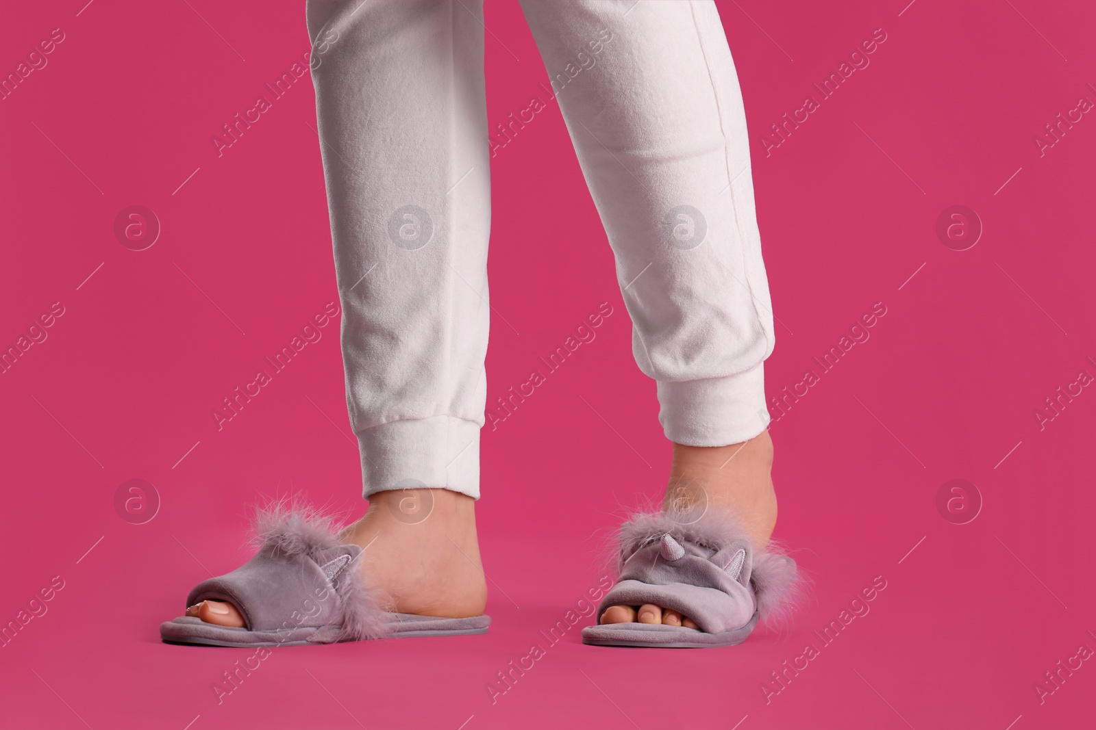 Photo of Woman in fluffy slippers on pink background, closeup