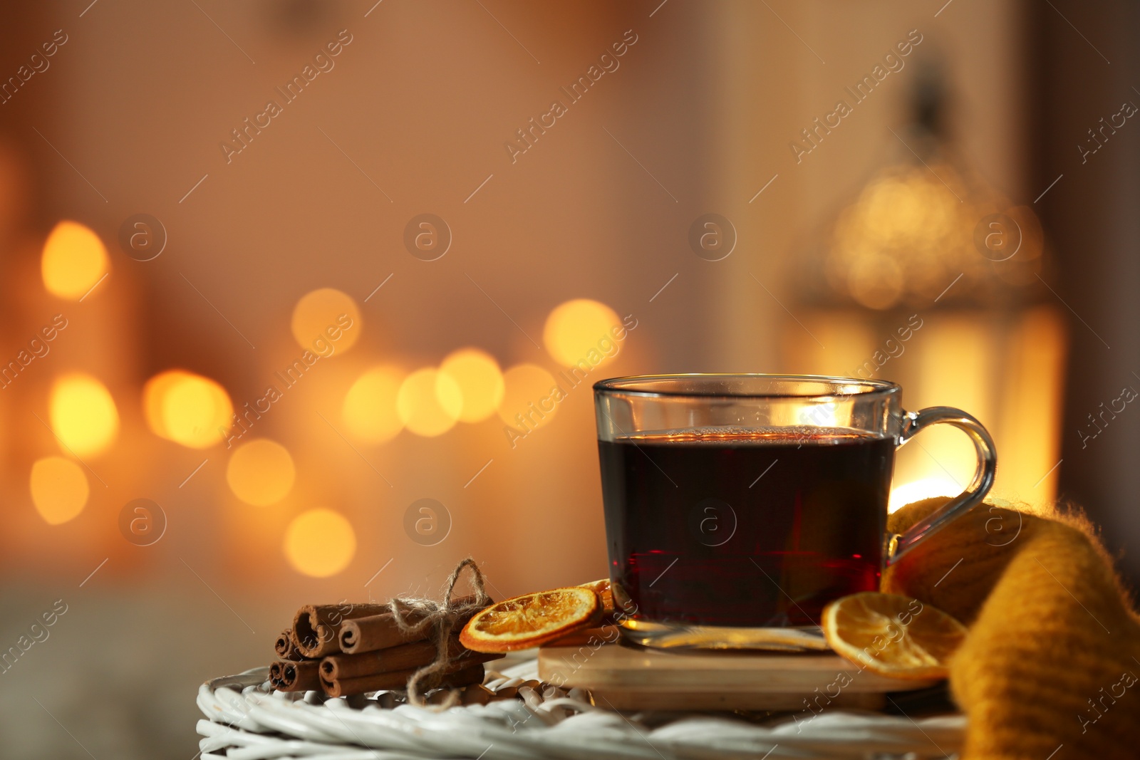 Photo of Cup of coffee on table against blurred lights, space for text. Cozy winter