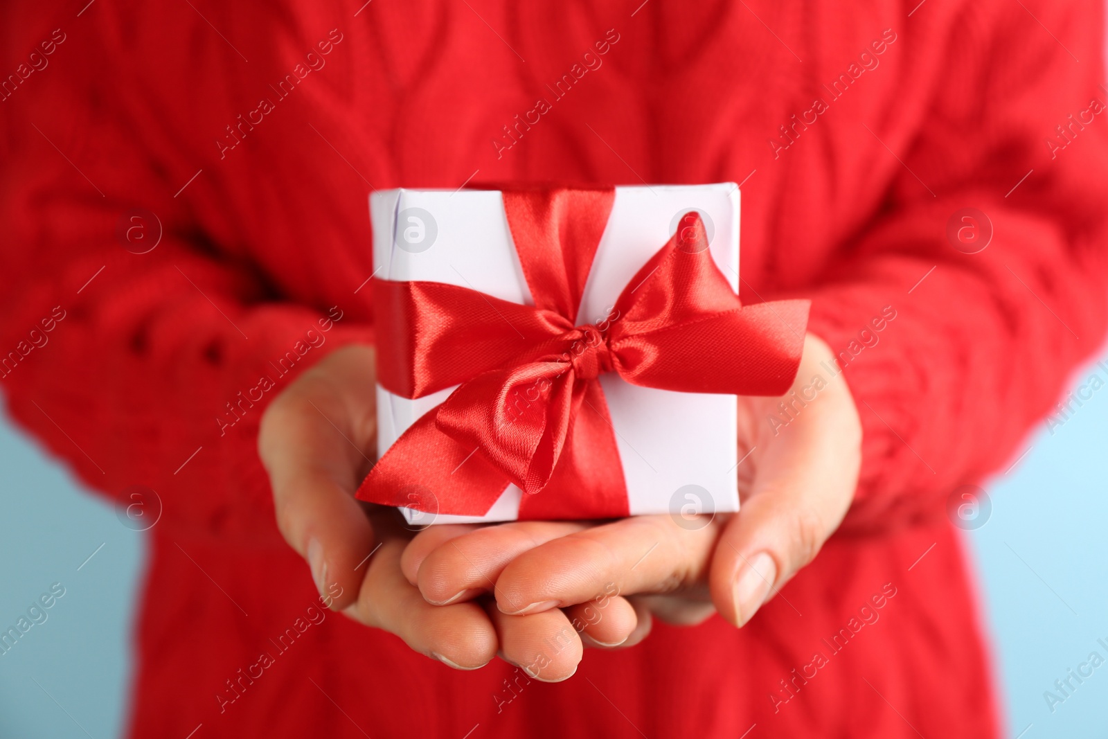 Photo of Woman holding gift box, closeup. Valentine's Day celebration