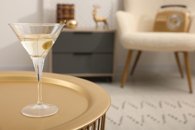 Photo of Martini cocktail with olive on table in room, space for text. Relax at home