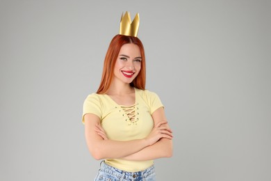 Photo of Beautiful young woman with princess crown on light grey background