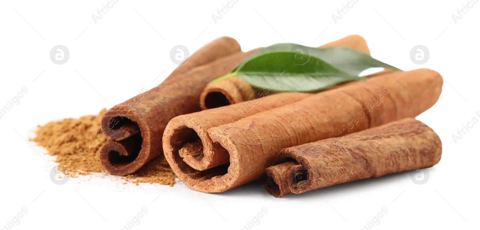 Photo of Dry aromatic cinnamon sticks, powder and green leaves isolated on white