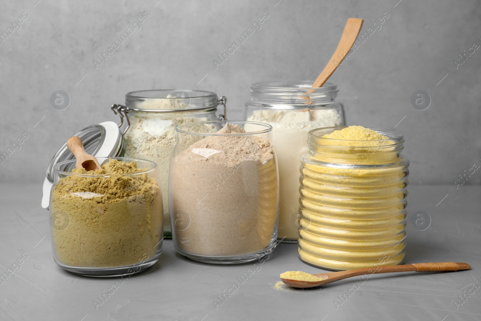 Photo of Jars with different types of flour on table