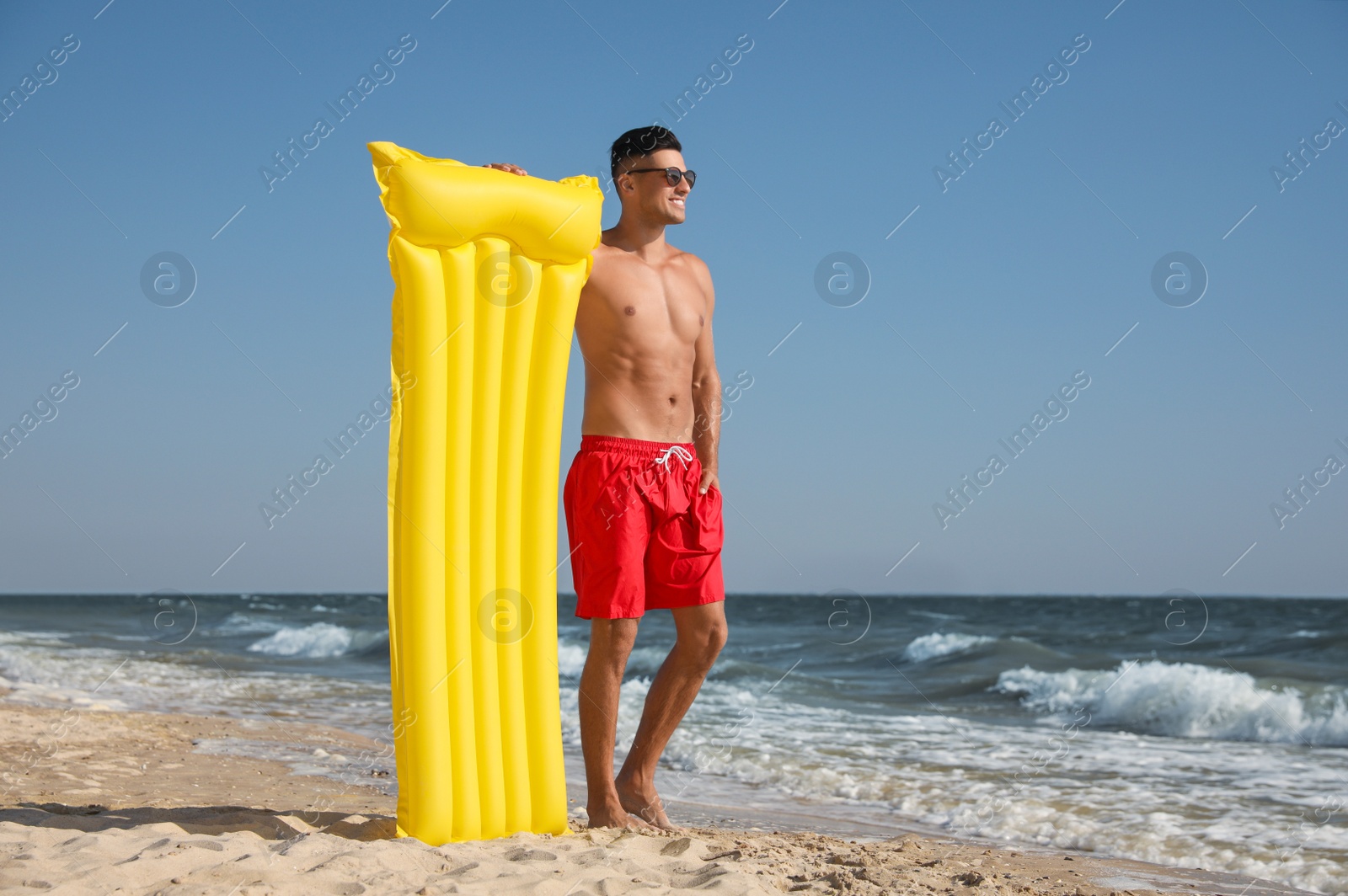 Photo of Man with yellow inflatable mattress at beach